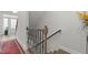 Stairwell features decorative iron railing, leading to natural light entryway with hardwood flooring and a patterned rug at 8410 Zinc Autumn Path, Raleigh, NC 27615
