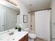Standard bathroom with white tile shower and cherry-cabinet sink at 8417 Henderson Rd, Apex, NC 27539