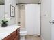 Standard bathroom with white tile shower and cherry-cabinet sink at 8417 Henderson Rd, Apex, NC 27539