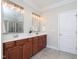 Bathroom with double sink vanity, granite countertop, modern lighting, and tiled shower at 8417 Henderson Rd, Apex, NC 27539