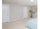 Bright bedroom with neutral carpet, walls, and trim and featuring two interior doors at 8417 Henderson Rd, Apex, NC 27539