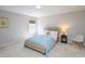 Cozy bedroom with a comfortable bed, side table with lamp, and neutral colored decor at 8417 Henderson Rd, Apex, NC 27539