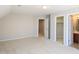 Spacious bedroom with neutral carpet and open doorway to a bathroom at 8417 Henderson Rd, Apex, NC 27539