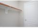 Bedroom walk-in closet with wooden closet rod, neutral walls, and a door at 8417 Henderson Rd, Apex, NC 27539