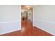 View of a dining area with wicker chairs through an open doorway and hardwood floors at 8417 Henderson Rd, Apex, NC 27539
