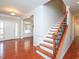 Inviting entryway with hardwood floors, a staircase, and a view into a living area at 8417 Henderson Rd, Apex, NC 27539