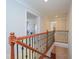 Hallway with hardwood railing looking into an open living space at 8417 Henderson Rd, Apex, NC 27539