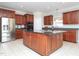 Gourmet kitchen with a granite island, stainless steel refrigerator, and wood cabinets for ample storage at 8417 Henderson Rd, Apex, NC 27539