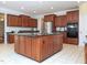 Expansive kitchen with an island, stainless steel refrigerator, and built-in microwave for modern convenience at 8417 Henderson Rd, Apex, NC 27539
