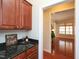 Butler's pantry features sleek black granite countertops and rich wood cabinetry, perfect for entertaining at 8417 Henderson Rd, Apex, NC 27539