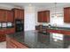 Stylish kitchen showcases granite countertops, a built-in microwave, and dark wood cabinets at 8417 Henderson Rd, Apex, NC 27539