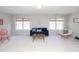 Sunlit living room with large windows, a blue sofa, and neutral-colored walls and carpet at 8417 Henderson Rd, Apex, NC 27539