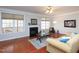 Hardwood living room featuring a fireplace, large windows, and neutral decor for a cozy ambiance at 8417 Henderson Rd, Apex, NC 27539