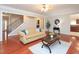 Bright living room with hardwood floors, neutral walls, sofa and connected to a kitchen area at 8417 Henderson Rd, Apex, NC 27539