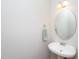 Powder room with a modern sink and stylish round mirror and sconce at 8417 Henderson Rd, Apex, NC 27539