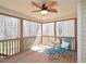 Screened porch with wicker furniture, ceiling fan, and forest view at 8417 Henderson Rd, Apex, NC 27539