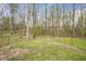 A spacious backyard with mature trees and a partial fence creates a serene setting at 900 Cricket Knoll Rd, Fuquay Varina, NC 27526