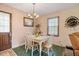 Cozy dining area features a charming chandelier, table with four chairs, and views through a window at 900 Cricket Knoll Rd, Fuquay Varina, NC 27526