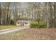 Sweet single-story home surrounded by lush trees, with a gravel driveway at 900 Cricket Knoll Rd, Fuquay Varina, NC 27526