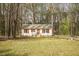Cozy single-story home featuring a quaint front porch, green lawn, and mature trees at 900 Cricket Knoll Rd, Fuquay Varina, NC 27526