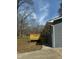 Side view of the house with grey brick wall, a wooden deck, and green grass at , Durham, NC 27712