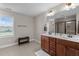 Bright bathroom features a double sink vanity, a large mirror, a bench, and a separate shower stall at 1036 Butterfly Cir, Wake Forest, NC 27587