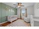 Bedroom with a white crib, colorful rug, and green accent wall at 1036 Butterfly Cir, Wake Forest, NC 27587