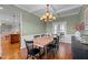 Traditional dining room with modern light fixture, hardwood floors, and sage green walls at 1036 Butterfly Cir, Wake Forest, NC 27587