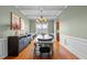 Traditional dining room with modern light fixture, hardwood floors, and wainscotting at 1036 Butterfly Cir, Wake Forest, NC 27587