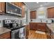 Well-lit kitchen featuring stainless steel appliances, granite countertops, and wood floors at 1036 Butterfly Cir, Wake Forest, NC 27587