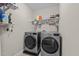 Functional laundry room with modern washer and dryer units and overhead shelving at 1036 Butterfly Cir, Wake Forest, NC 27587