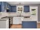 Modern kitchen with blue cabinets, granite countertops, stainless steel appliances, and a white subway tile backsplash at 105 Seminole Dr, Wendell, NC 27591