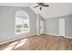 Spacious living room featuring vaulted ceilings, wood-look floors, and a large arched window at 105 Seminole Dr, Wendell, NC 27591