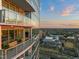 Modern building with multiple balconies, glass railings, and views of the city at sunset at 110 N Corcoran St # 2302, Durham, NC 27701