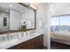 Elegant bathroom with double sinks, marble countertops, and a view of the bedroom and city beyond at 110 N Corcoran St # 2302, Durham, NC 27701