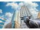 A striking statue in front of modern high-rise buildings set against a bright blue sky with scattered clouds at 110 N Corcoran St # 2302, Durham, NC 27701