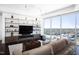 Modern living room featuring built-in shelves, a large window with city views, and comfortable furniture at 110 N Corcoran St # 2302, Durham, NC 27701