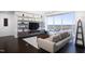 Modern living room featuring built-in shelves, a large window with city views, and contemporary furniture at 110 N Corcoran St # 2302, Durham, NC 27701