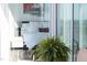 Modern bedroom with white bedding, city artwork, and plant in the foreground seen through glass doors at 110 N Corcoran St # 2302, Durham, NC 27701