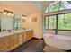 Bright bathroom features a soaking tub, double vanity, and stylish fixtures with a beautiful view at 111 Standing Rock Rd, Chapel Hill, NC 27516