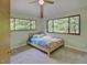 Bright bedroom featuring two large windows offering serene outdoor views and a ceiling fan at 111 Standing Rock Rd, Chapel Hill, NC 27516