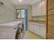 Well-organized laundry room featuring a washer, dryer, sink, white cabinets, and ample storage space at 111 Standing Rock Rd, Chapel Hill, NC 27516