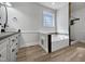 Bathroom includes tiled bath, a modern vanity, and natural lighting through the window at 117 Pierce Rd, Garner, NC 27529