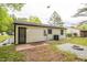 Rear exterior showcasing white siding, an air conditioning unit, gravel fire pit area, and landscaping at 1204 Pecan Pl, Durham, NC 27704