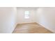 Bright, empty bedroom with light hardwood flooring, fresh paint, and natural light from a window at 1204 Pecan Pl, Durham, NC 27704