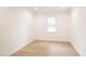 Bright bedroom with wood-look floors, large window, and neutral walls at 1204 Pecan Pl, Durham, NC 27704