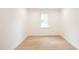 Bright, empty bedroom featuring light hardwood flooring, fresh paint, a window and modern baseboards at 1204 Pecan Pl, Durham, NC 27704