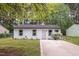 Attractive single-story home with white siding, black trim, landscaping, and concrete driveway at 1204 Pecan Pl, Durham, NC 27704