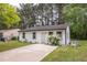 Inviting single-story home with white siding, black trim, landscaping and a concrete driveway at 1204 Pecan Pl, Durham, NC 27704