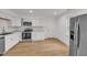 Bright kitchen features white cabinets, stainless steel appliances, and wood-look flooring at 1204 Pecan Pl, Durham, NC 27704